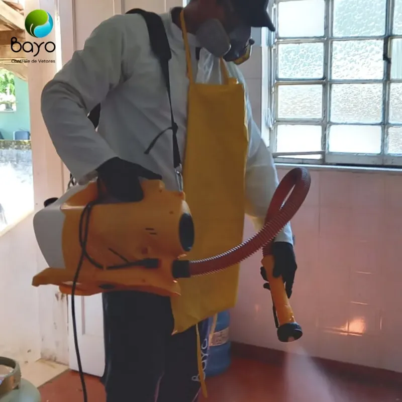 Técnico da Bayo com EPI e avental aplicando produto com atomizador