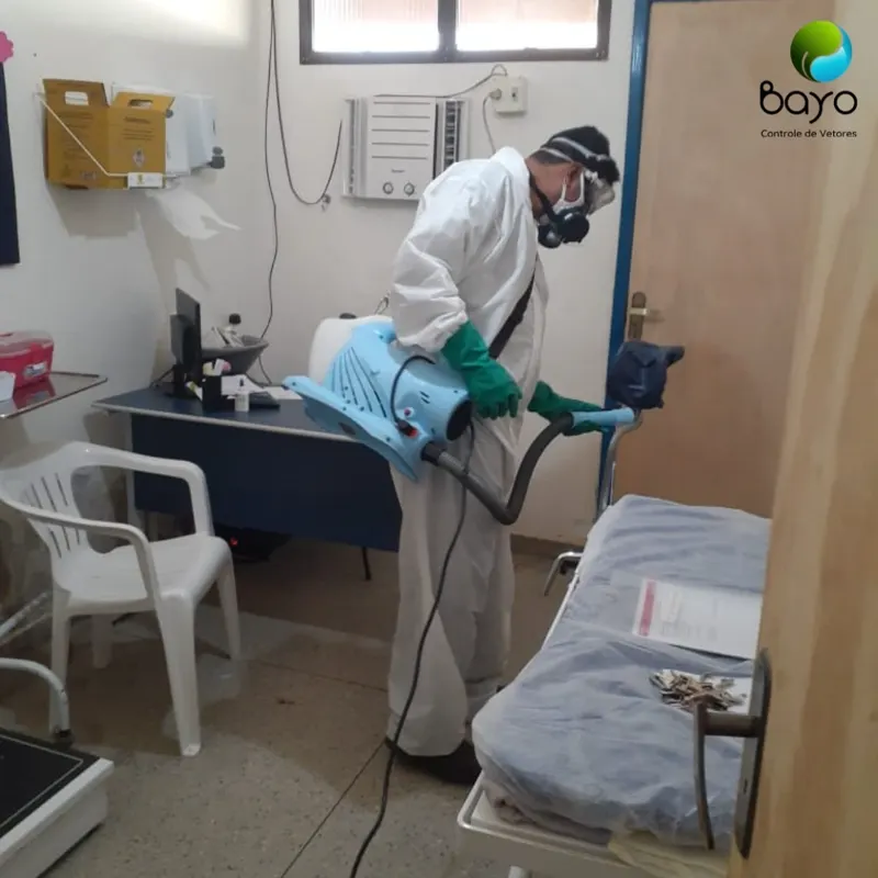 Técnico da Bayo com EPI completo aplicando produto em consultório